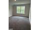 An inviting bedroom with neutral walls and plush carpet features a large window with scenic outdoor views at 3382 Milan Ct # 3 Plapprox Sqft 3, Douglasville, GA 30135