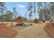 Spacious backyard featuring a wooden playset, a grill on wooden deck, surrounded by mature trees and a wood fence at 20 Manor Oak Ln, Covington, GA 30014