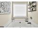 Bright bathroom with a large tub, decorative art, and shelves with plants at 20 Manor Oak Ln, Covington, GA 30014