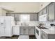 A well lit kitchen with subway tile backsplash, white appliances and grey cabinets at 20 Manor Oak Ln, Covington, GA 30014