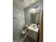 Bathroom featuring modern marble-style tile, updated vanity, and contemporary lighting fixtures at 8463 Alden Dr, Riverdale, GA 30274