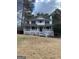 Front view showcasing this two-story home with white siding, a covered porch, and mature trees at 57 Kristina Ct, Acworth, GA 30101