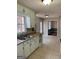 Kitchen featuring tile flooring, white cabinets, and stainless steel sink with a view to the backyard at 57 Kristina Ct, Acworth, GA 30101