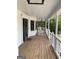 Relaxing covered porch with wood floors, hanging lantern, rocking chairs and white railings at 57 Kristina Ct, Acworth, GA 30101