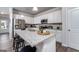 Well-lit kitchen with stainless steel appliances, white cabinets, granite countertops, and bar seating at 1492 Trellis Court (Lot 44), Hampton, GA 30228