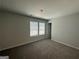 Well-lit bedroom featuring neutral walls, plush carpeting, and a large window with natural light at 1825 Harmony Trce # 6, Lithonia, GA 30058