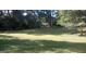 Backyard featuring a lush green lawn, surrounded by mature trees and landscaping at 2421 Rockbridge Sw Rd, Stone Mountain, GA 30087