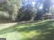 Spacious backyard with a covered carport and mature trees offering a private and serene setting at 2421 Rockbridge Sw Rd, Stone Mountain, GA 30087