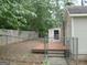 Fenced backyard featuring a small deck area and a storage shed, providing privacy and extra storage space at 2421 Rockbridge Sw Rd, Stone Mountain, GA 30087