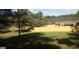 Large backyard showcasing a green lawn, surrounding trees and an enclosed wooden fence at 2421 Rockbridge Sw Rd, Stone Mountain, GA 30087
