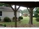 View of a large backyard with mature trees and landscaping, as seen from under a covered area at 2421 Rockbridge Sw Rd, Stone Mountain, GA 30087