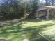 Picturesque backyard featuring a covered carport, grassy lawn, and mature trees providing ample shade at 2421 Rockbridge Sw Rd, Stone Mountain, GA 30087
