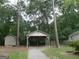 Covered carport parking with additional storage shed on a landscaped lot at 2421 Rockbridge Sw Rd, Stone Mountain, GA 30087