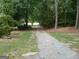Long, paved driveway leading through a tree-lined property, offering a sense of privacy and seclusion at 2421 Rockbridge Sw Rd, Stone Mountain, GA 30087
