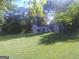 Well-maintained front lawn with mature trees and a charming cottage-style home at 2421 Rockbridge Sw Rd, Stone Mountain, GA 30087