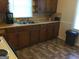 Traditional kitchen with wood cabinets, dual basin sink, and tile flooring at 2421 Rockbridge Sw Rd, Stone Mountain, GA 30087