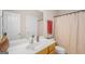 Bathroom with wood cabinets, and a shower curtain with patterned details at 101 Kenmare Row, Tyrone, GA 30290