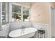 Bathroom featuring a claw foot tub with wainscoting and a large window at 101 Kenmare Row, Tyrone, GA 30290