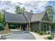 Craftsman home showing stone and shingle carport design with a curved driveway and mature landscaping at 101 Kenmare Row, Tyrone, GA 30290