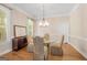Bright dining room with hardwood floors, chandelier, and elegant furniture near the large window at 101 Kenmare Row, Tyrone, GA 30290
