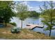 Picturesque lake view with a wooden pier, a picnic table, and mature trees on a sunny day at 101 Kenmare Row, Tyrone, GA 30290