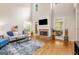 Spacious living room with stone fireplace, tall ceilings, and ample natural light at 101 Kenmare Row, Tyrone, GA 30290