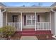 Inviting front porch with a cozy seating area, columns, and a view of the landscaped yard at 3645 Fay Dr, Rex, GA 30273