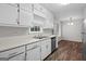 Bright kitchen features white cabinetry, stainless steel appliances, and wood-look floors at 3645 Fay Dr, Rex, GA 30273