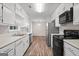 Open kitchen features stainless steel appliances, white cabinetry, and wood-look flooring at 3645 Fay Dr, Rex, GA 30273