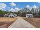 Long driveway leads to a blue two-story home with a matching detached garage on a beautiful lot at 283 Shoemake Rd, Carrollton, GA 30116