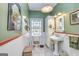 Charming bathroom featuring a pedestal sink, built-in storage, and stained glass window at 86 Victoria Dr, Moreland, GA 30259