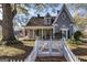 Quaint home with a covered front porch, white picket fence, and mature landscaping at 86 Victoria Dr, Moreland, GA 30259