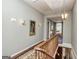 Well-lit hallway with hardwood floors, decorative lighting, and stairway access at 86 Victoria Dr, Moreland, GA 30259