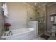 Bathroom featuring a soaking tub, a glass shower, and neutral tile at 6422 Paulson, Atlanta, GA 30328