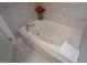 Close-up on a white soaking bathtub with neutral tile surround at 6422 Paulson, Atlanta, GA 30328