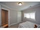 Bedroom with a twin bed, gray walls, white trim, a window, and doorway to the bathroom at 6422 Paulson, Atlanta, GA 30328