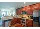 An open kitchen features stainless steel appliances, granite countertops, and rich wood cabinetry at 6422 Paulson, Atlanta, GA 30328