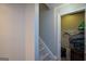 Stairway to basement with carpeted stairs, and an open closet with shelf, blankets, and storage containers at 6422 Paulson, Atlanta, GA 30328