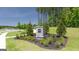 Community entrance featuring stone monument, landscaping, and decorative trees at 8591 Seabiscuit Rd # 113, Lithonia, GA 30058