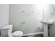 A half bathroom has a pedestal sink, mirror, and toilet with gray vinyl flooring at 5827 Highgrove Dr, Atlanta, GA 30349