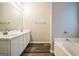 Bathroom featuring dual sinks, a large mirror, and a built-in tub at 5827 Highgrove Dr, Atlanta, GA 30349