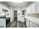 Modern kitchen featuring stainless steel appliances, white cabinets, gray walls, and modern vinyl flooring at 5827 Highgrove Dr, Atlanta, GA 30349