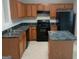 Kitchen with wooden cabinetry, black appliances, and countertop island for an efficient workspace at 2941 Vining Ridge Ter, Decatur, GA 30034