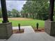 Picturesque backyard view features a spacious lawn with verdant trees, and brick support structures at Lot C Montannas Way, Moreland, GA 30259