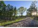 Gravel driveway leading up to a property through mature trees, showcasing the natural setting and serene environment at Lot C Montannas Way, Moreland, GA 30259