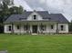 Charming single-story home with a welcoming front porch and lush green lawn at Lot C Montannas Way, Moreland, GA 30259