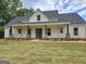 Beautifully constructed single story home showcasing a covered front porch and professional landscaping at Lot C Montannas Way, Moreland, GA 30259