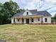 Beautiful newly constructed single story home showcasing a covered front porch and professional landscaping at Lot C Montannas Way, Moreland, GA 30259