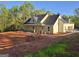 New construction home featuring light yellow siding, a dark gray roof, and an attached garage in a wooded area at Lot C Montannas Way, Moreland, GA 30259