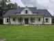 Charming single-story home with a welcoming front porch and lush green lawn at Lot C Montannas Way, Moreland, GA 30259